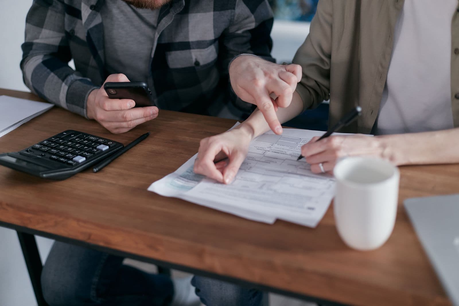 Hands working through paperwork with a calculator