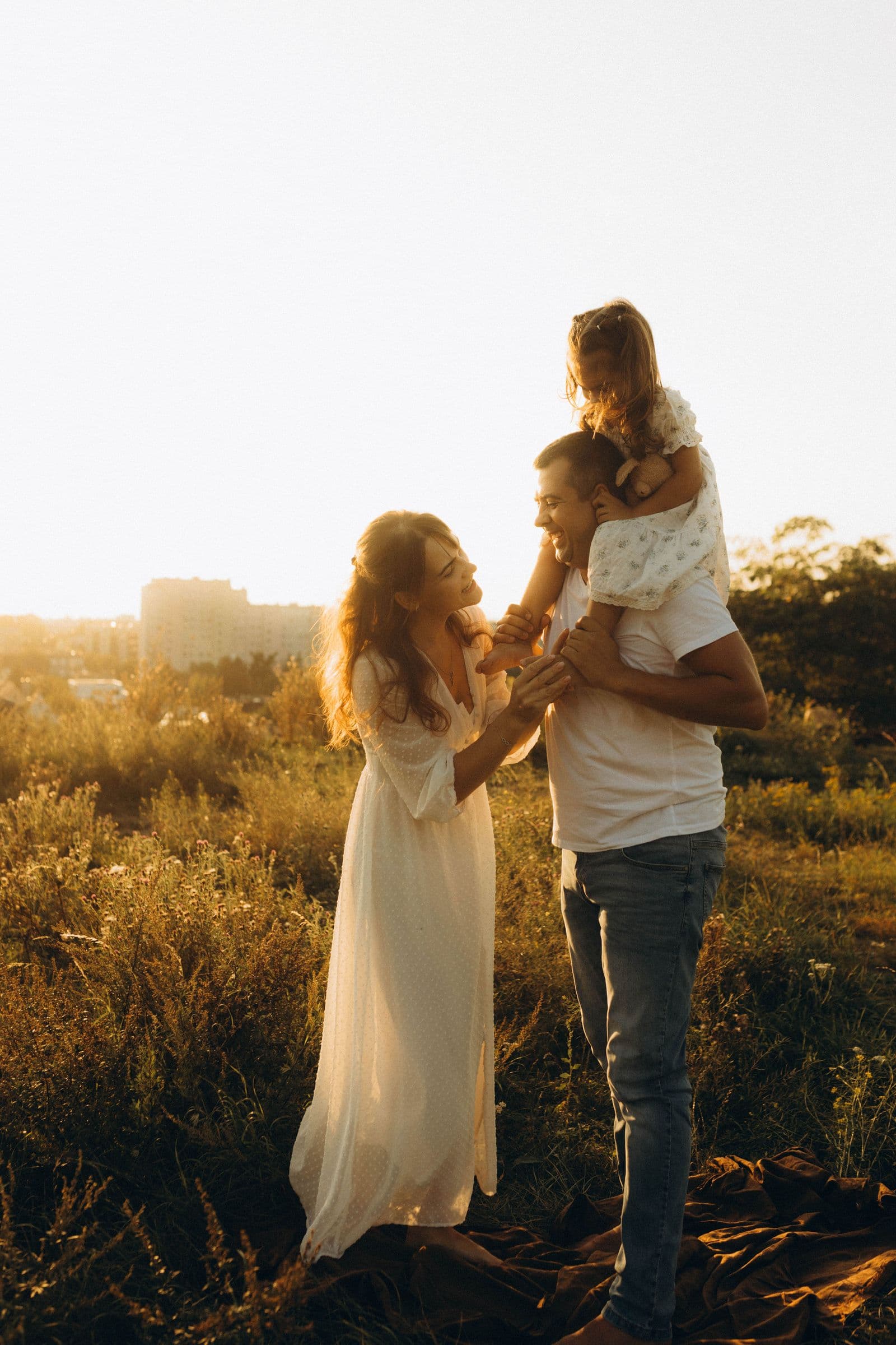 A family walking through a sunny field at golden hour